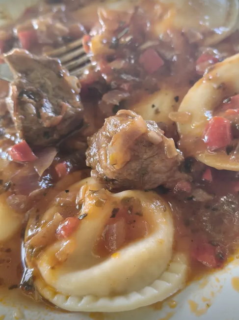 Raviolones con salsa y bondiola braseada