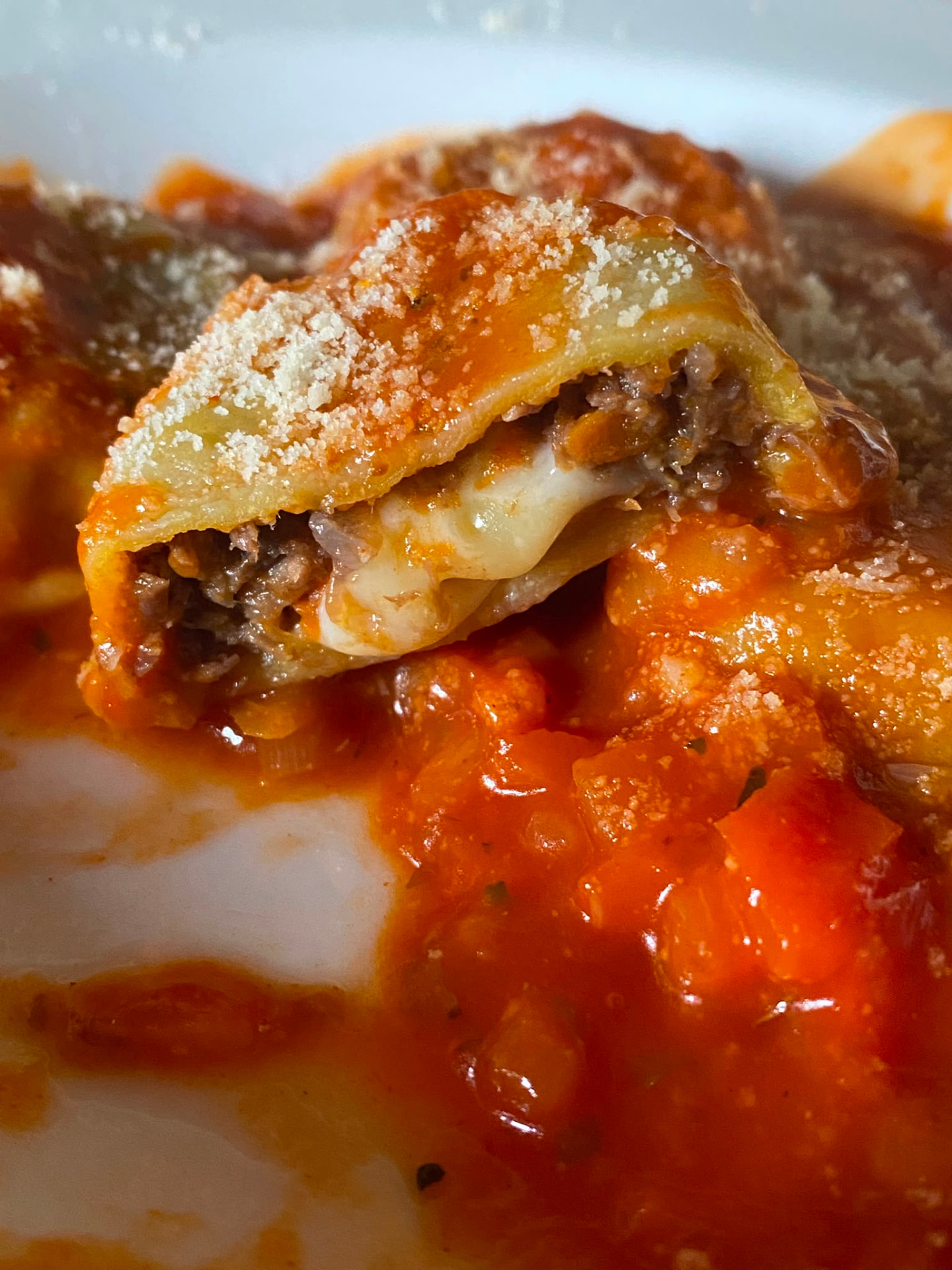 Sorrentino cortado a la mitad con relleno de carne y muzzarella en salsa